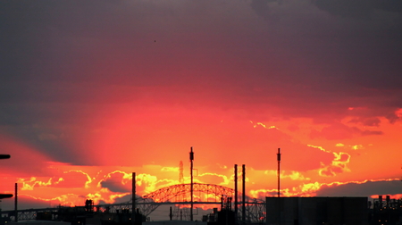 Colorful red sunrise, daylight, at the port of Corpus Christi, USA Wiev of port facilities and ships in the rays of the waning sun.の写真素材