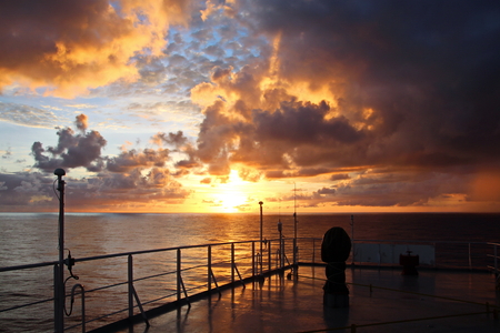 Sunset in the Pacific Ocean. Different types of sunset from the side of the ship while driving and anchoring at the port. Riot of colors of the ocean, clouds and sun.の写真素材