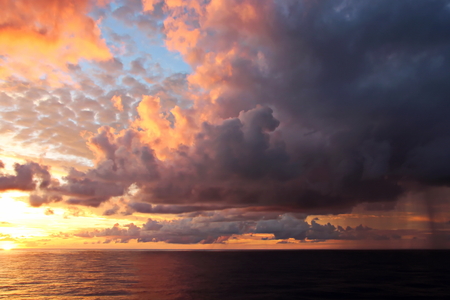 Sunset in the Pacific Ocean. Different types of sunset from the side of the ship while driving and anchoring at the port. Riot of colors of the ocean, clouds and sun.の写真素材