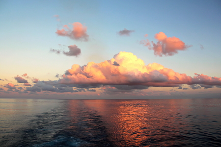 Sunset in the Pacific Ocean. Different types of sunset from the side of the ship while driving and anchoring at the port. Riot of colors of the ocean, clouds and sun.の写真素材
