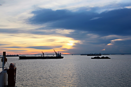 Sunset in the Pacific Ocean. Different types of sunset from the side of the ship while driving and anchoring at the port. Riot of colors of the ocean, clouds and sun.の写真素材