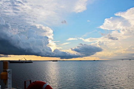 Sunset in the Pacific Ocean. Different types of sunset from the side of the ship while driving and anchoring at the port. Riot of colors of the ocean, clouds and sun.の写真素材