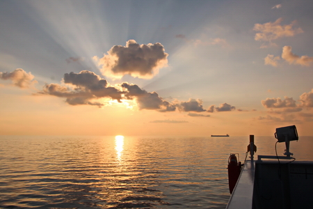 Sunset in the Pacific Ocean. Different types of sunset from the side of the ship while driving and anchoring at the port. Riot of colors of the ocean, clouds and sun.の写真素材
