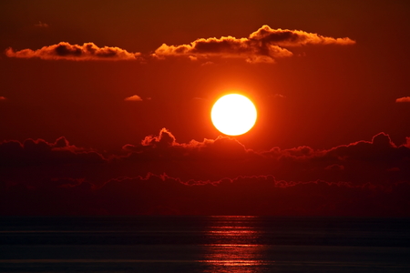 Sunset in the Pacific Ocean. Different types of sunset from the side of the ship while driving and anchoring at the port. Riot of colors of the ocean, clouds and sun.の写真素材
