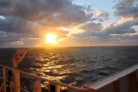 Sunset in the Pacific Ocean. Different types of sunset from the side of the ship while driving and anchoring at the port. Riot of colors of the ocean, clouds and sun.の写真素材