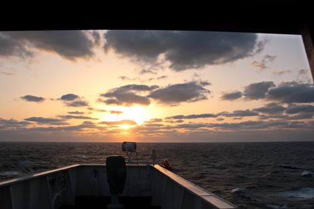 Sunset in the Pacific Ocean. Different types of sunset from the side of the ship while driving and anchoring at the port. Riot of colors of the ocean, clouds and sun.の写真素材