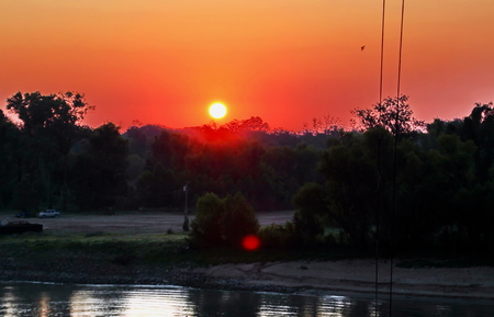 Sunset on the Mississippi River, New Orleans Port, USA. Colorful sunset against the sky, water and river bank.の写真素材