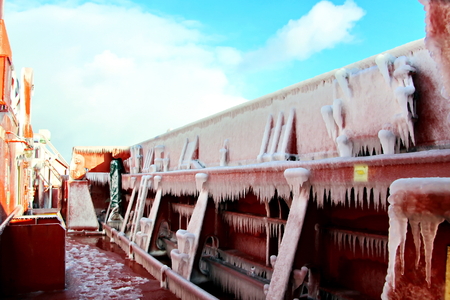 Ice of the ship and ship structures after sailing in frosty weather. Ice patterns and icicles, the play of light, ice and sun.の写真素材
