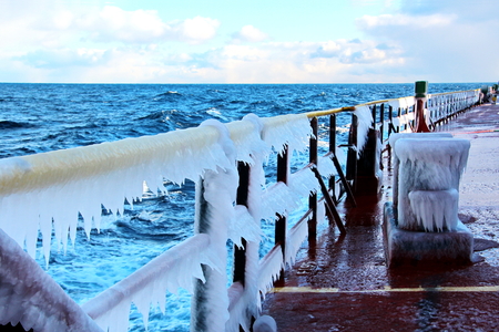 Ice of the ship and ship structures after sailing in frosty weather. Ice patterns and icicles, the play of light, ice and sun.の写真素材