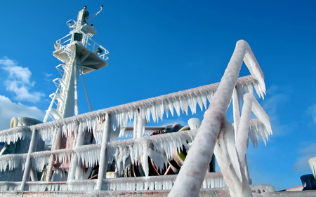 Ice of the ship and ship structures after sailing in frosty weather. Ice patterns and icicles, the play of light, ice and sun.の写真素材