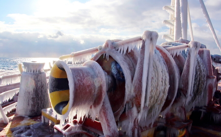 Ice of the ship and ship structures after sailing in frosty weather. Ice patterns and icicles, the play of light, ice and sun.の写真素材