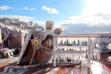 Ice of the ship and ship structures after sailing in frosty weather. Ice patterns and icicles, the play of light, ice and sun.の写真素材