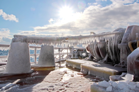 Ice of the ship and ship structures after sailing in frosty weather. Ice patterns and icicles, the play of light, ice and sun.の写真素材