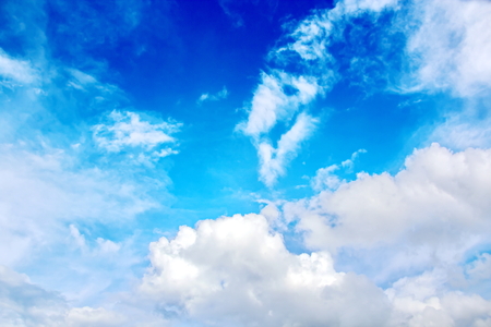 The clouds are multicolored, thunderous bizarre shapes against the blue sky and the sun above the ocean surface. The game of light and shadows in various variations of sunlight illumination of clouds and sky.の写真素材