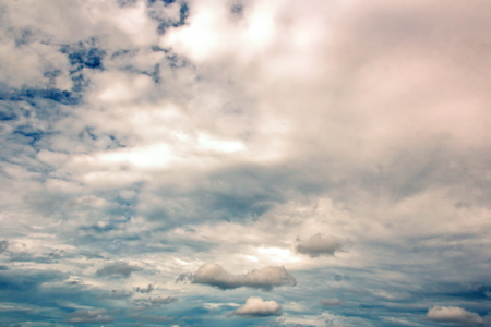 The clouds are multicolored, thunderous bizarre shapes against the blue sky and the sun above the ocean surface. The game of light and shadows in various variations of sunlight illumination of clouds and sky.の写真素材