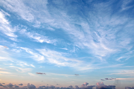 The clouds are multicolored, thunderous bizarre shapes against the blue sky and the sun above the ocean surface. The game of light and shadows in various variations of sunlight illumination of clouds and sky.の写真素材