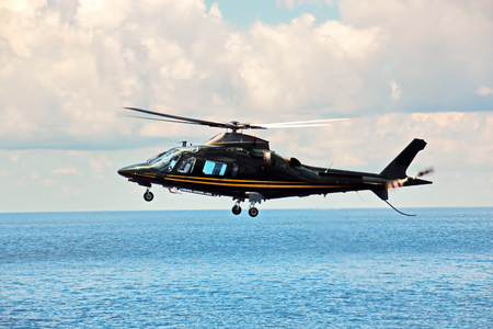 Helicopter as the main means of landing and acceptance of sea pilots for sea vessels in Australian waters, 2018. View of a helicopter close-up against a blue sky and a sea ship.の写真素材