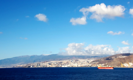 Colorful view of the coast of the Canary Islands and the port of Las Palmas against the blue sky and clouds from the side of the sea ship anchored. February, 2012.の写真素材