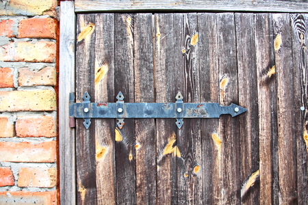 Ancient wooden gates and doors in the castle with elements of locks, handles and fasteners closeup.の写真素材