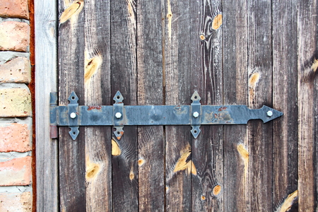 Ancient wooden gates and doors in the castle with elements of locks, handles and fasteners closeup.の写真素材