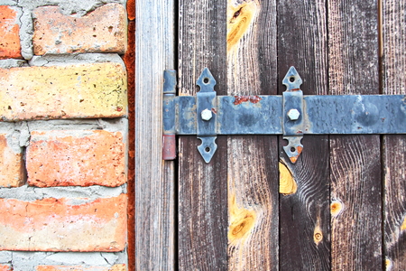 Ancient wooden gates and doors in the castle with elements of locks, handles and fasteners closeup.の写真素材