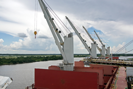 Transhipment terminal for loading bulk cargo of chemical sulphur to sea bulk carriers using a shore crane. Port Beaumont, Texas, USA. July, 2017.の写真素材