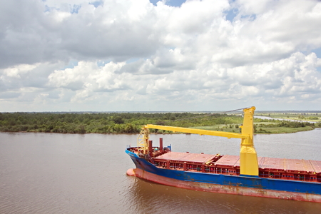 The movement of sea merchant ships and tugs to the entrance and exit from the port. View of the river Neches. Port Beaumont, Texas, USA. July 2017.の写真素材
