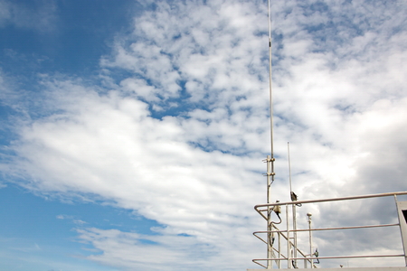Ship structures, masts, antennas, funnel, ship wheelhouse against the blue sky and clouds.の写真素材