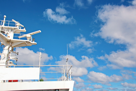Ship structures, masts, antennas, funnel, ship wheelhouse against the blue sky and clouds.の写真素材