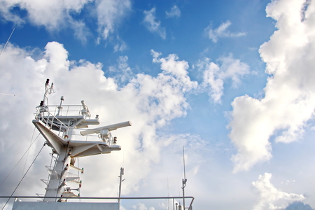 Ship structures, masts, antennas, funnel, ship wheelhouse against the blue sky and clouds.の写真素材