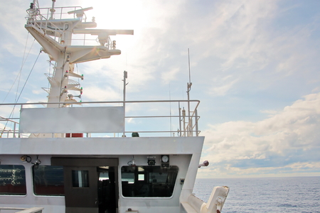 Ship structures, masts, antennas, funnel, ship wheelhouse against the blue sky and clouds.の写真素材