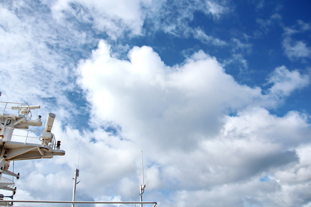 Ship structures, masts, antennas, funnel, ship wheelhouse against the blue sky and clouds.の写真素材