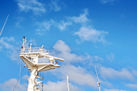 Ship structures, masts, antennas, funnel, ship wheelhouse against the blue sky and clouds.の写真素材