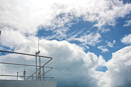 Ship structures, masts, antennas, funnel, ship wheelhouse against the blue sky and clouds.の写真素材