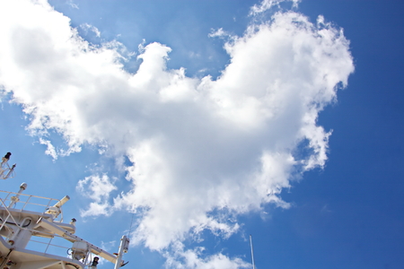 Ship structures, masts, antennas, funnel, ship wheelhouse against the blue sky and clouds.の写真素材