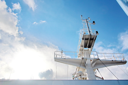 Ship structures, masts, antennas, funnel, ship wheelhouse against the blue sky and clouds.の写真素材