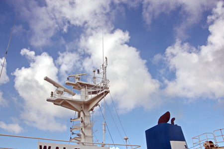 Ship structures, masts, antennas, funnel, ship wheelhouse against the blue sky and clouds.の写真素材
