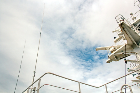 Ship structures, masts, antennas, funnel, ship wheelhouse against the blue sky and clouds.の写真素材