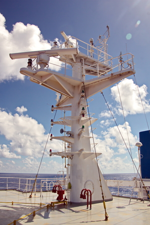 Ship structures, masts, antennas, funnel, ship wheelhouse against the blue sky and clouds.の写真素材