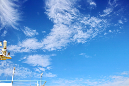 Ship structures, masts, antennas, funnel, ship wheelhouse against the blue sky and clouds.の写真素材