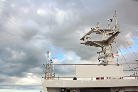 Ship structures, masts, antennas, funnel, ship wheelhouse against the blue sky and clouds.の写真素材