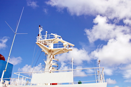 Ship structures, masts, antennas, funnel, ship wheelhouse against the blue sky and clouds.の写真素材