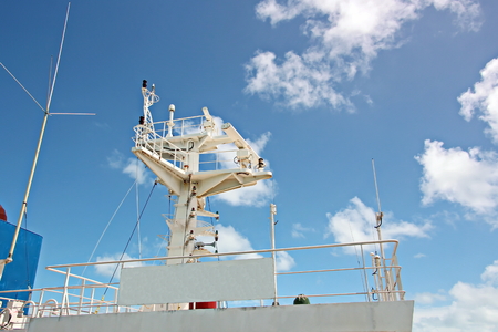 Ship structures, masts, antennas, funnel, ship wheelhouse against the blue sky and clouds.の写真素材