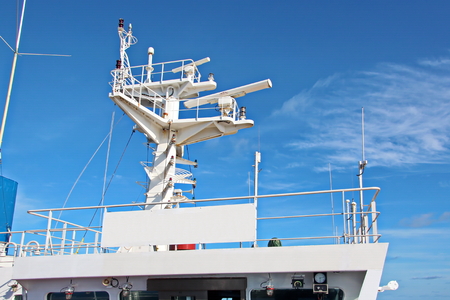 Ship structures, masts, antennas, funnel, ship wheelhouse against the blue sky and clouds.の写真素材