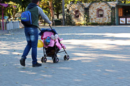 Odessa, Ukraine. March, 2020. Family Day. Parents' active leisure on foot with children in wheelchairs, roller skates, bicycles on city streets and in the park.のeditorial素材