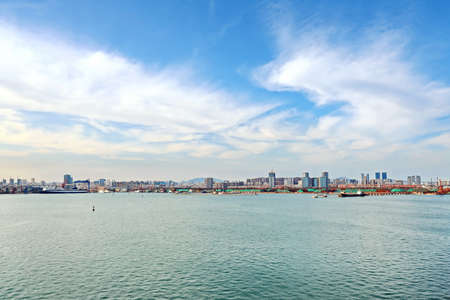 Panoramic views of piers, sea vessels, tugboats and the city of Rizhao, China.の写真素材