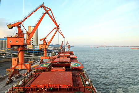 Cargo terminal for unloading grain cargo by coastal cranes. Port Jiangyin, China. December, 2019.