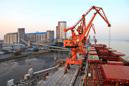Cargo terminal for unloading grain cargo by coastal cranes. Port Jiangyin, China. December, 2019.