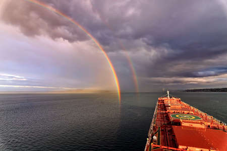 Colorful views of the rainbow against the sky, clouds and sea horizon. Commencement Bay, Tacoma, WA,...