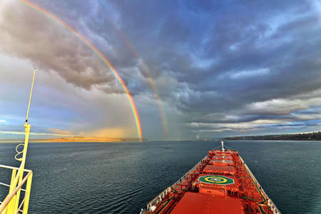 Colorful views of the rainbow against the sky, clouds and sea horizon. Commencement Bay, Tacoma, WA, USAの写真素材